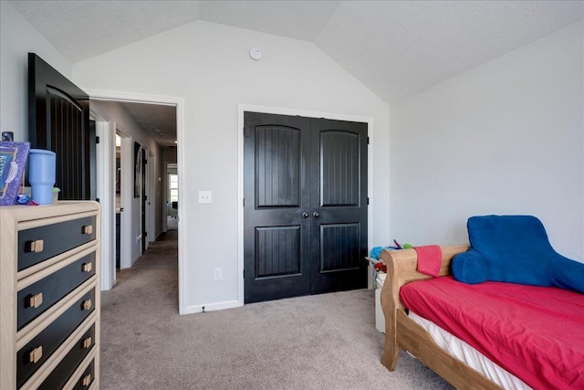 bedroom with a closet, carpet flooring, and lofted ceiling