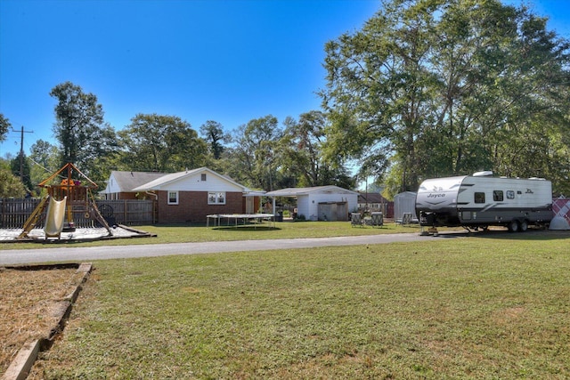 view of yard with a playground and a trampoline