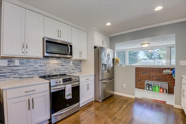 kitchen with light stone counters, appliances with stainless steel finishes, decorative backsplash, white cabinets, and ornamental molding