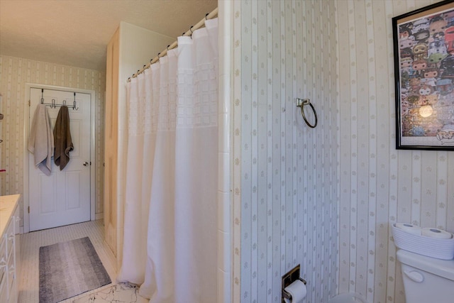 bathroom with a shower with curtain, toilet, a textured ceiling, and vanity