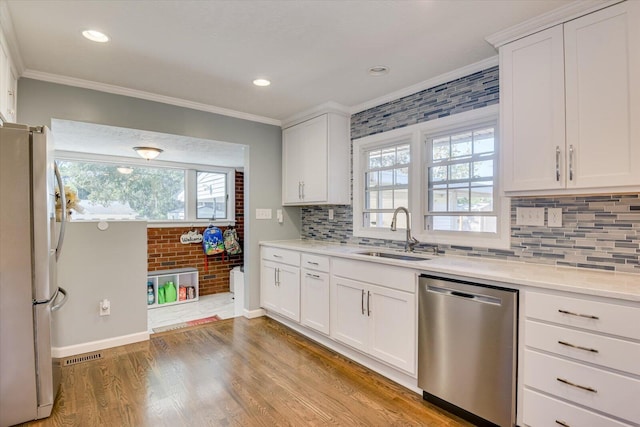 kitchen with a healthy amount of sunlight, sink, white cabinetry, and stainless steel appliances