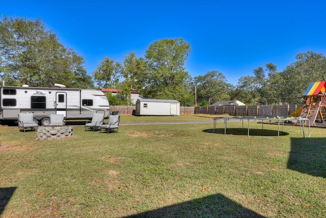 view of yard featuring a playground, a trampoline, and a shed