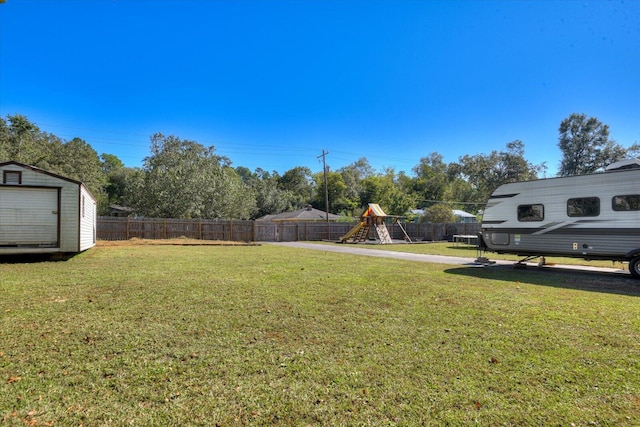 view of yard featuring a storage unit and a playground