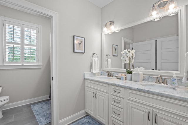 3108 Wildflower Ct, Evans, GA 30809 - bathroom featuring toilet, double vanity, and baseboards