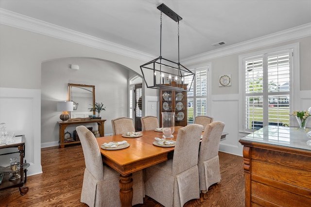 3108 Wildflower Ct, Evans, GA 30809 - dining room featuring a chandelier, arched walkways, ornamental molding, dark wood finished floors, and a wainscoted wall