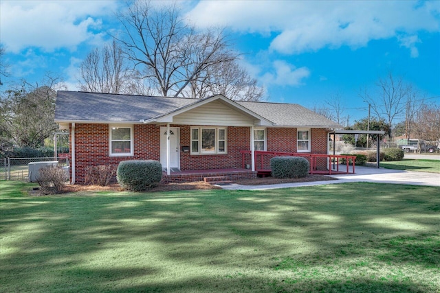 single story home featuring brick siding, roof with shingles, a front yard, and fence