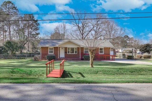 view of front of home with a carport, a front yard, brick siding, and fence