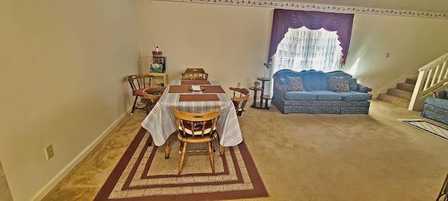 dining space featuring baseboards, stairs, and carpet