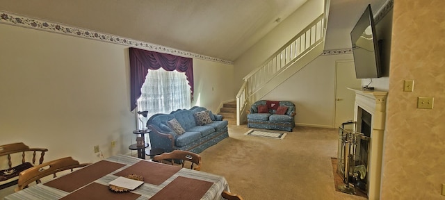 living area with lofted ceiling, stairway, carpet flooring, and a fireplace