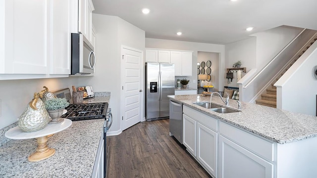 1255 Birch Cir, Grovetown, GA 30813 - kitchen with appliances with stainless steel finishes, a sink, dark wood-style flooring, a kitchen island with sink, and white cabinetry