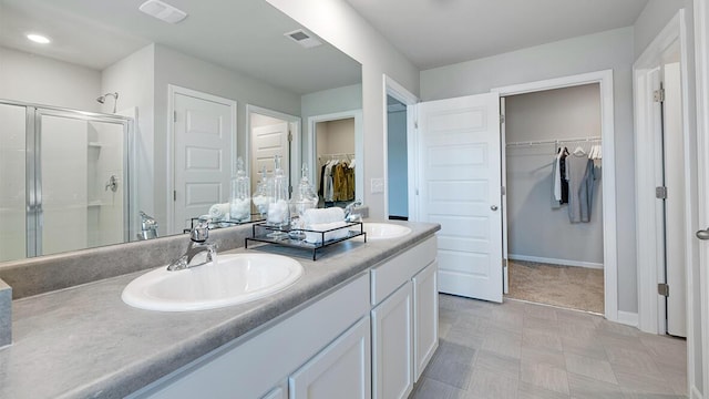 1255 Birch Cir, Grovetown, GA 30813 - bathroom featuring double vanity, a walk in closet, a shower stall, and baseboards