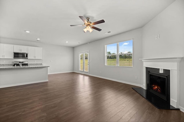 1255 Birch Cir, Grovetown, GA 30813 - unfurnished living room with a ceiling fan, a warm lit fireplace, dark wood-style floors, recessed lighting, and baseboards