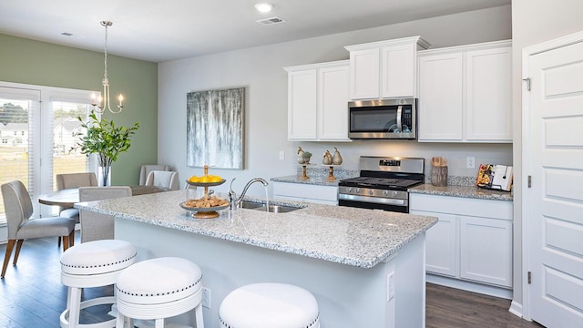 1255 Birch Cir, Grovetown, GA 30813 - kitchen with stainless steel appliances, a sink, dark wood finished floors, a breakfast bar, and light stone countertops