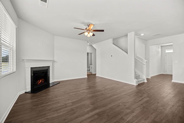 1255 Birch Cir, Grovetown, GA 30813 - unfurnished living room featuring ceiling fan, stairway, a warm lit fireplace, dark wood-type flooring, and baseboards