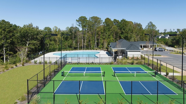 view of tennis court with fence and a fenced in pool