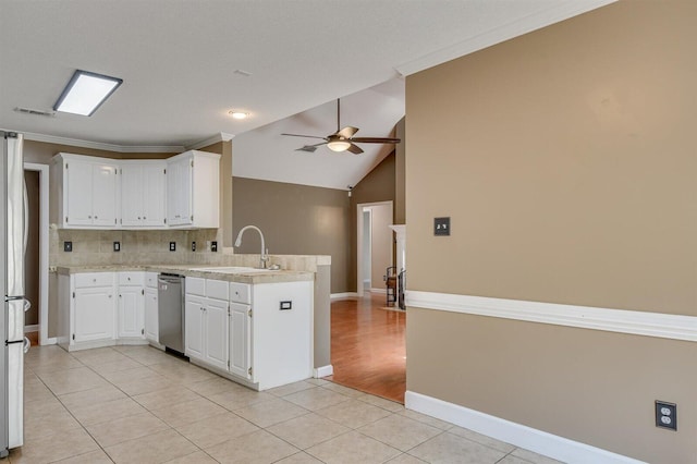 kitchen featuring kitchen peninsula, appliances with stainless steel finishes, sink, light tile patterned floors, and white cabinetry