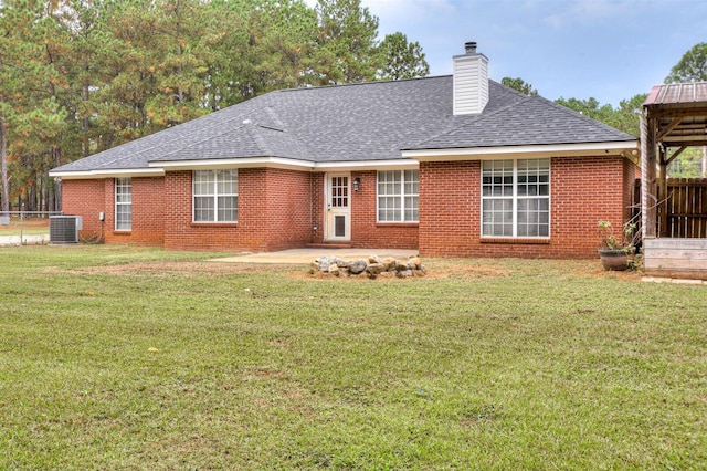 back of property with a yard, a patio, and central air condition unit