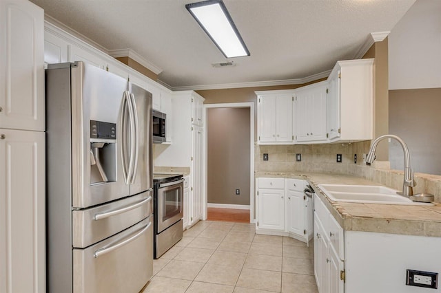 kitchen featuring light tile patterned floors, white cabinetry, and appliances with stainless steel finishes