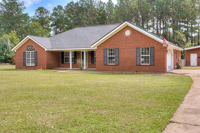 ranch-style house with covered porch, a garage, and a front lawn