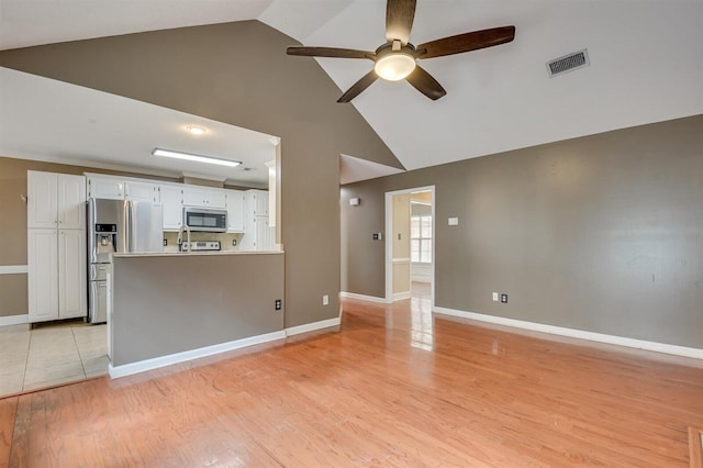 unfurnished living room featuring ceiling fan, high vaulted ceiling, and light wood-type flooring