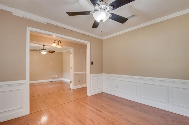 empty room with hardwood / wood-style flooring, an inviting chandelier, and ornamental molding