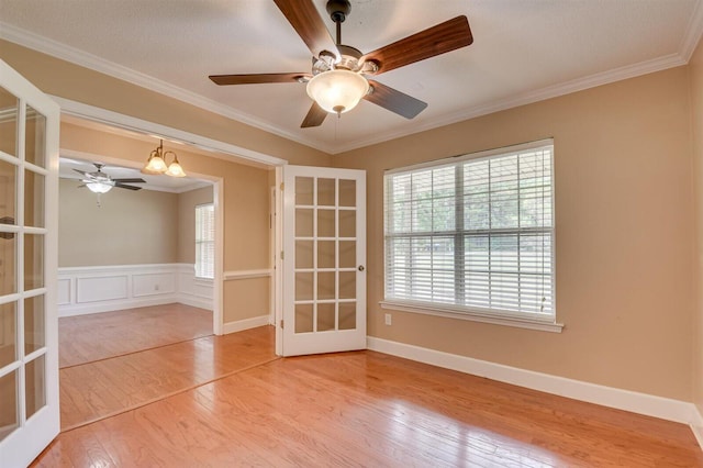 spare room featuring hardwood / wood-style flooring, french doors, an inviting chandelier, and ornamental molding