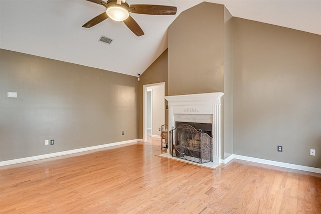 unfurnished living room featuring high vaulted ceiling, light hardwood / wood-style flooring, ceiling fan, and a tiled fireplace