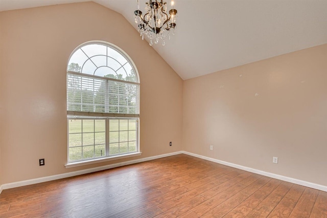 unfurnished room featuring vaulted ceiling, wood-type flooring, and an inviting chandelier