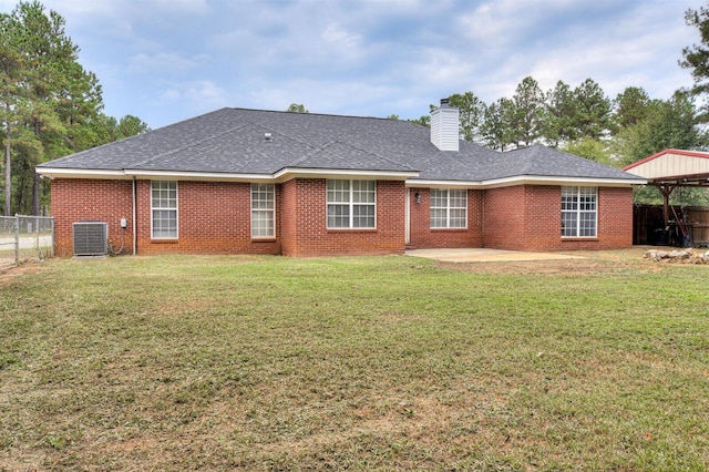 rear view of property with central AC, a patio area, and a yard