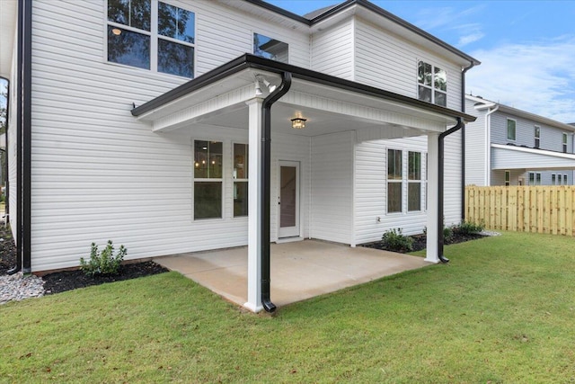 rear view of property featuring a patio area and a lawn