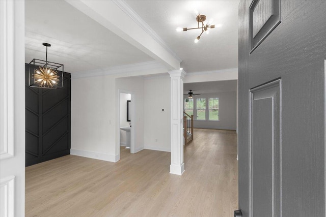 interior space featuring ceiling fan with notable chandelier, ornamental molding, light hardwood / wood-style flooring, and decorative columns