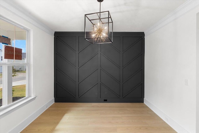 unfurnished dining area featuring light hardwood / wood-style floors, crown molding, and a notable chandelier