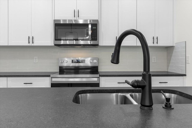 kitchen featuring tasteful backsplash, sink, white cabinets, and stainless steel appliances