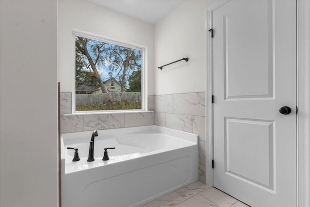 bathroom featuring a tub to relax in and tile walls