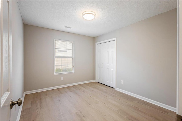 612 Creek Bottom Trl, Grovetown, GA 30813 - unfurnished bedroom featuring light wood-style floors, a closet, and a textured ceiling