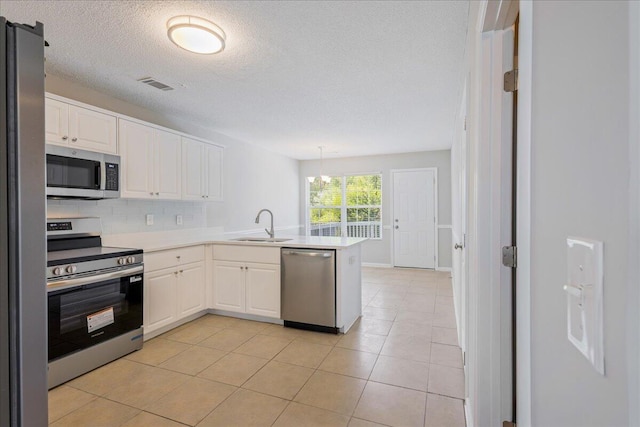 612 Creek Bottom Trl, Grovetown, GA 30813 - kitchen featuring stainless steel appliances, a peninsula, white cabinetry, tasteful backsplash, and a textured ceiling