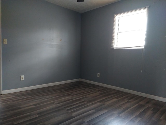 empty room with dark hardwood / wood-style flooring