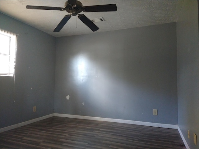 spare room with a textured ceiling, dark hardwood / wood-style floors, and ceiling fan