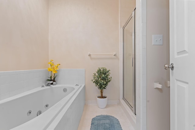 bathroom with a tub with jets, a shower stall, and tile patterned floors