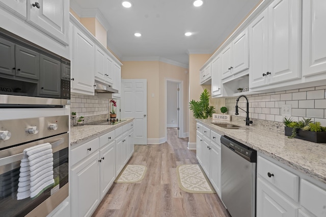 kitchen featuring crown molding, stainless steel appliances, light wood-style floors, white cabinets, and a sink