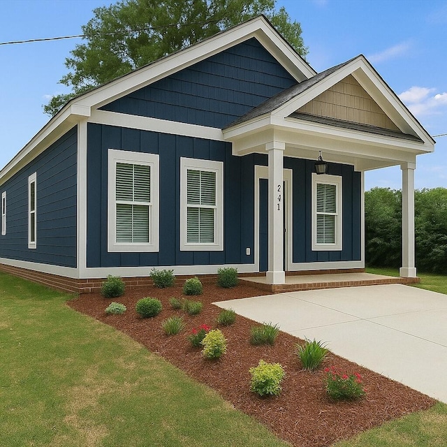 241 Walker St, Augusta, GA 30901 - view of front facade featuring board and batten siding, covered porch, and a front yard