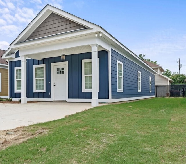 241 Walker St, Augusta, GA 30901 - shotgun-style home with board and batten siding, a front yard, and covered porch