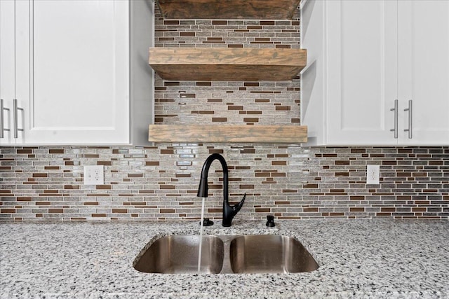241 Walker St, Augusta, GA 30901 - kitchen view of a sink, decorative backsplash, white cabinetry, and light stone countertops