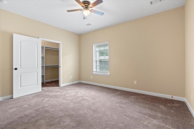 241 Walker St, Augusta, GA 30901 - unfurnished bedroom with carpet flooring, baseboards, a walk in closet, a closet, and a ceiling fan