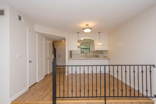 327 Joshua Tree Dr, Martinez, GA 30907 - kitchen with white cabinetry, light wood-type flooring, freestanding refrigerator, baseboards, and decorative light fixtures