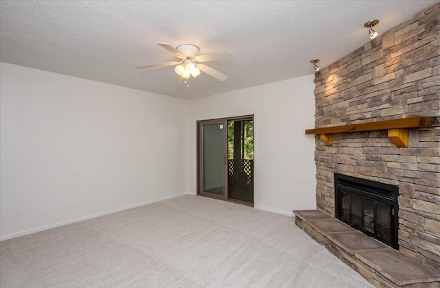 327 Joshua Tree Dr, Martinez, GA 30907 - unfurnished living room with light colored carpet, ceiling fan, a stone fireplace, a textured ceiling, and baseboards