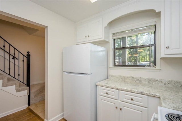 327 Joshua Tree Dr, Martinez, GA 30907 - kitchen featuring freestanding refrigerator, white cabinets, wood finished floors, baseboards, and light stone counters