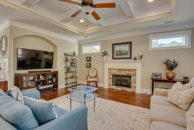 living room with dark hardwood / wood-style flooring, a healthy amount of sunlight, a stone fireplace, and coffered ceiling