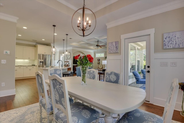 dining space with coffered ceiling, ceiling fan with notable chandelier, crown molding, dark hardwood / wood-style floors, and beam ceiling