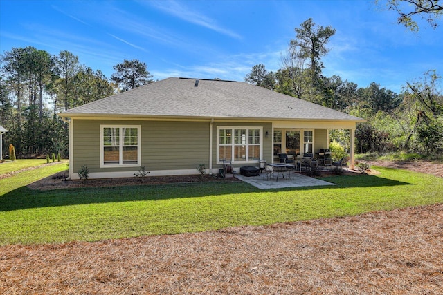 rear view of property featuring a lawn and a patio